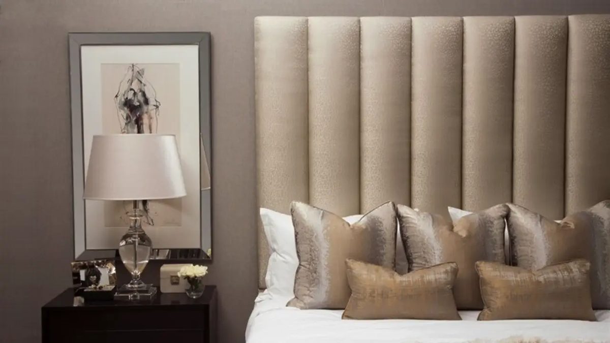 Fluted cream upholstered headboard behind a hotel-style bed